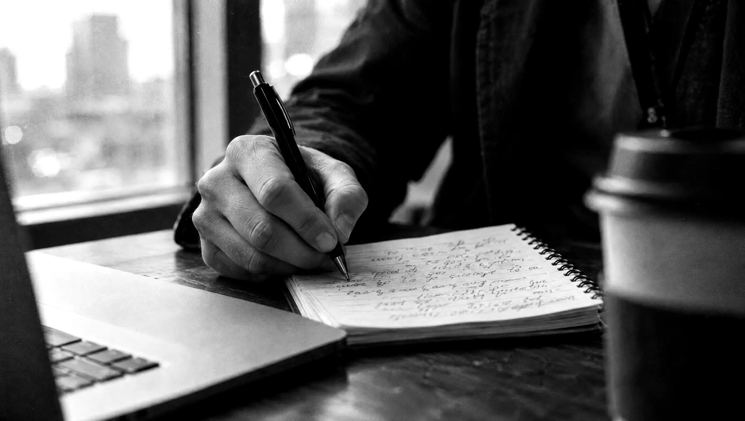 A journalist writing notes in a reporter's notebook