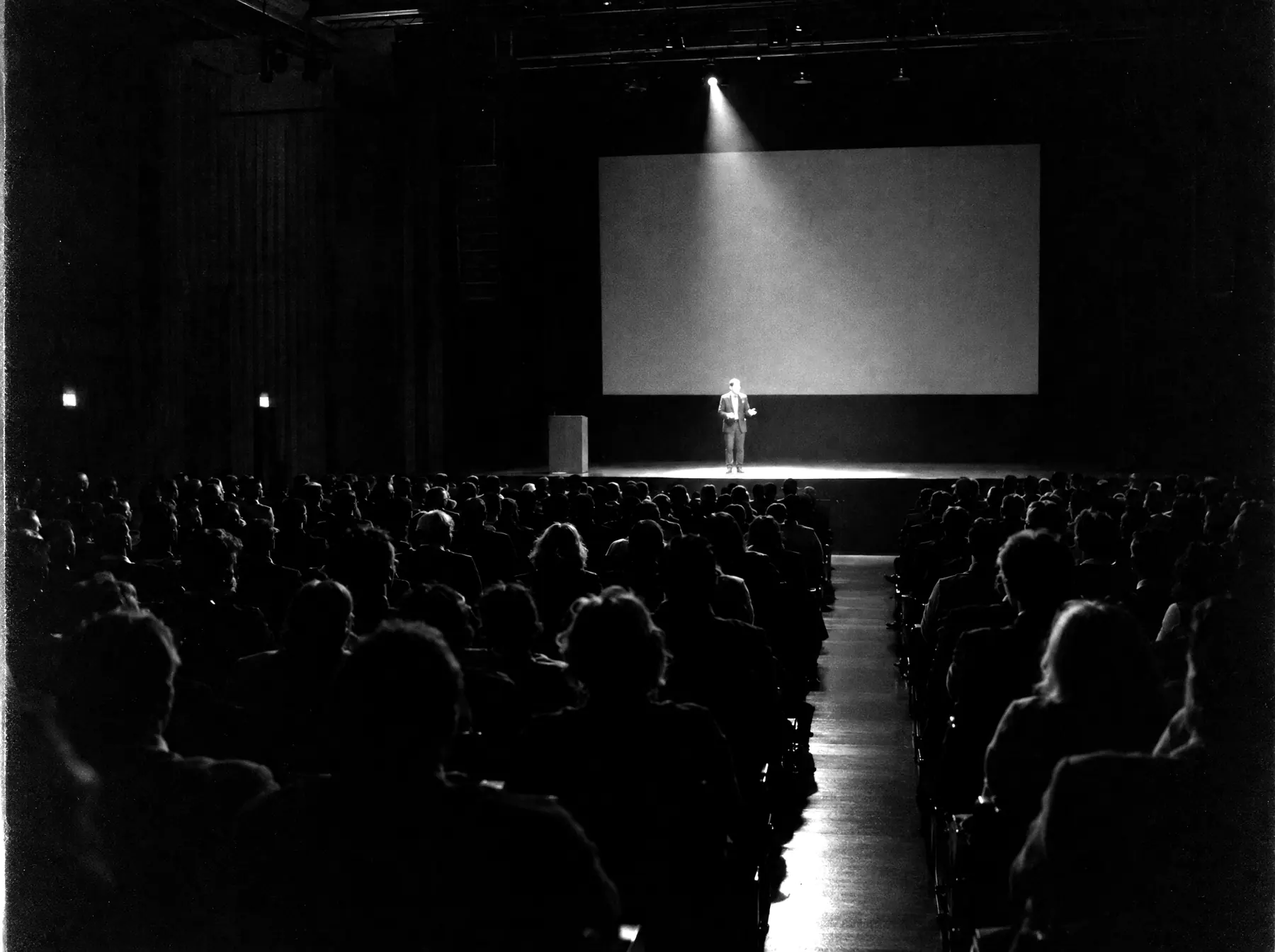 Audience watching a speaker on stage at a conference